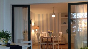 A dining area with a table and chairs, a lamp, and a vase with flowers. - Alla Ghigliotta holiday home (Viverone)