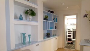 A hallway with white shelves containing decorative items and a plant. There is a door leading to another room. - Alla Ghigliotta holiday home (Viverone)