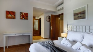 Una habitación de hotel con una cama, un escritorio, una mesita de noche y obras de arte en las paredes.