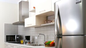 A modern kitchen with a stainless steel refrigerator, a microwave, and a coffee maker. - Casa Alessandra 2bdr (Oranjestad-West)