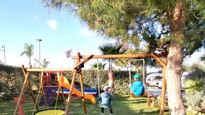 Un parque infantil con columpios y un tobogán.