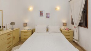 A bedroom with a bed, two bedside tables, a mirror, and wall-mounted lights. - Apartment Maresia, 50 metres from the Oura Beach and 2 minutes from the Strip (Albufeira)