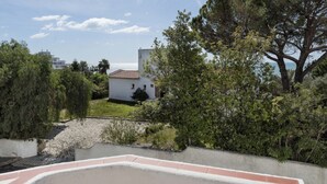 A white building with a red-tiled roof, surrounded by greenery and a clear sky. - Apartment Maresia, 50 metres from the Oura Beach and 2 minutes from the Strip (Albufeira)