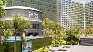 A modern building with a curved facade and the name "PARIS" prominently displayed. - Azure Tropical Paradise in your Backyard (Parañaque)