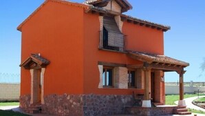 A two-story house with a stone foundation, a red exterior, and a balcony. - RURAL HOUSE FOR 2 PEOPLE IN TUREGANO (Turégano)