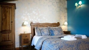 A bedroom with a wooden headboard, two bedside tables with lamps, a bed with a patterned duvet, and a wardrobe. - RURAL HOUSE FOR 2 PEOPLE IN TUREGANO (Turégano)