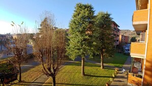 Uma área residencial com gramado, árvores e um edifício com varanda.