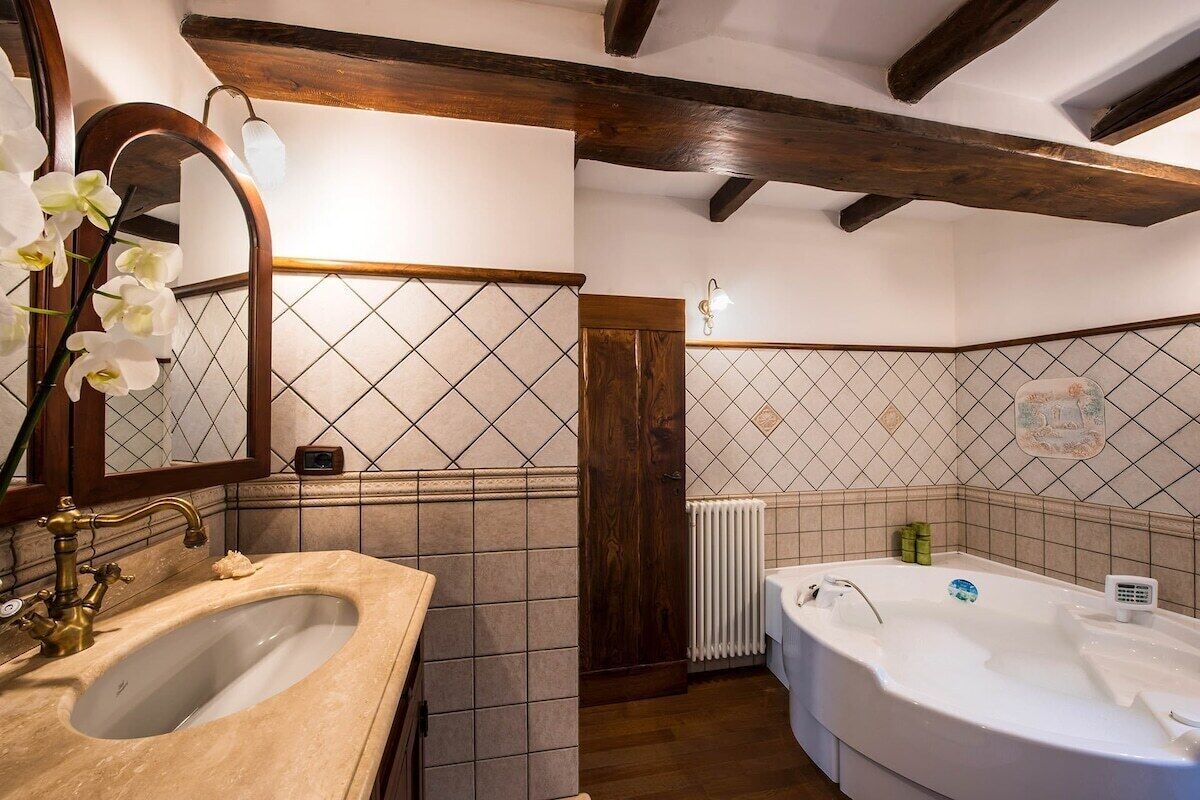 A bathroom with a sink, mirror, and bathtub.