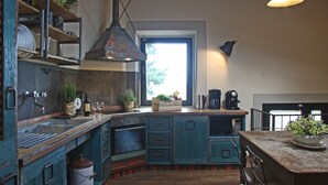 Een keuken met een houten aanrecht, een inbouwoven en een hangende lamp.