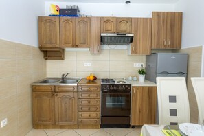 Réfrigérateur, un four, surface de cuisson, vaisselle et ustensiles