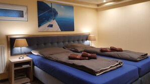 A bedroom with a large bed, two bedside tables, a headboard, and a painting of a boat on a dock. - Vacation home in Arnstadt for up to 8 people more on request (Arnstadt)