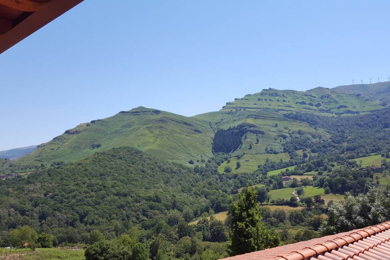 A view of rolling green hills with a clear sky.