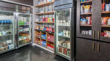 Interior de um supermercado, com seções refrigeradas e prateleiras repletas de diversos alimentos.