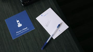 A business card, a signed document, and a pen on a dark wooden surface.
