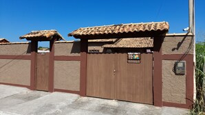 A building with a brown exterior and a tiled roof. - Itaipuaçu Residências Cajueiros II (Maricá)