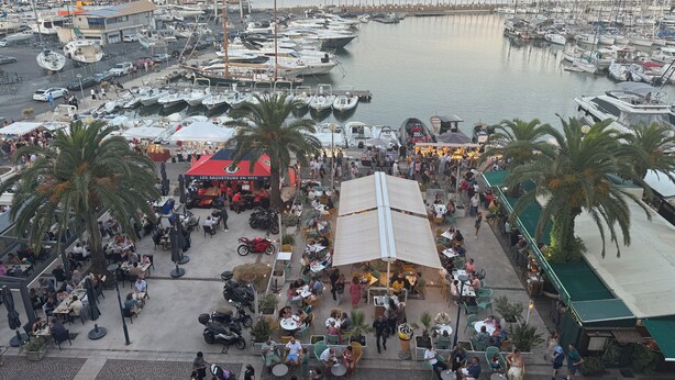 A marina with boats docked, outdoor seating areas, and palm trees. - Upscale apartment in a quiet location, accessible for disabled people (Hyères)