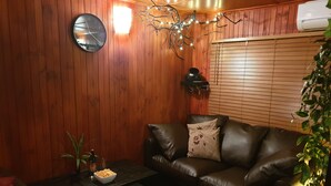 Un salon chaleureux avec un canapé en cuir, une table basse et un mur en bois.