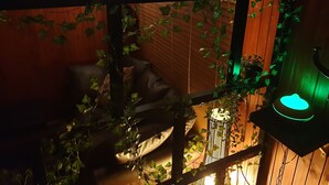 Une pièce chaleureuse aux murs en bois, avec un lit et une lampe qui diffuse une lumière verte.