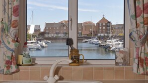 A bathroom with a window view of a marina, a toothbrush holder, and toiletries. - Three floor townhouse next to the water for families and friends with 3 bedrooms (Eastbourne)