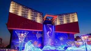 Un bâtiment moderne doté d’une architecture originale, caractérisé par une grande façade vitrée et un atrium central.
