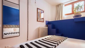 A modern bedroom with a bed, a large mirror, a radiator, and a window with curtains. - Laguna Boutique Apartments | 2-bedroom with patio & parking in Venice Mestre (Venezia)