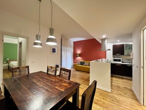 A modern apartment with a dining area, kitchen, and living space.