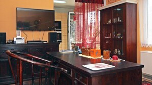 A dining area with a wooden table, chairs, a television, and a cabinet with various items. - Beautiful apartment for 4 guests with WIFI, TV and terrace (Vienna)