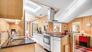 Una cocina moderna con paneles de madera, una isla central y un horno empotrado.