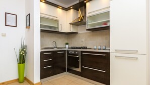 Una cocina moderna con armarios oscuros, una campana de acero inoxidable y un horno empotrado.