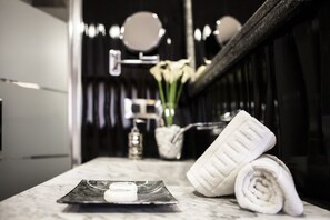 Een bad/douchecombinatie, een bubbelbad, een haardroger, handdoeken