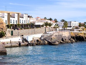 A coastal hotel with a stone facade, a swimming pool, and a staircase leading to the beach. - Nice terrace apartment, shared pool - PORÍS 2 (Porís de Abona)