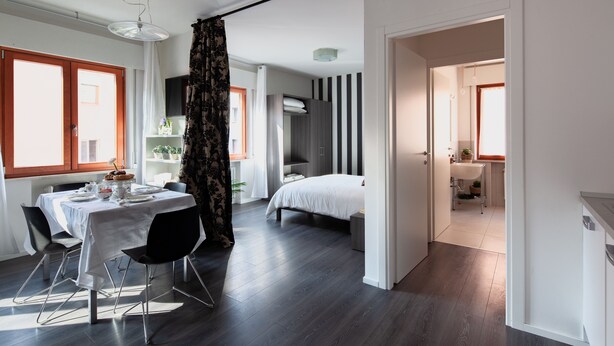 Une chambre d’hôtel moderne comprenant un coin repas, un lit et une salle de bain.