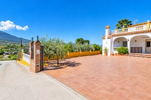 A residential property with a paved courtyard, a brick entrance gate, and a yellow wall. - Cubo's Casa María los Javieles / free wifi / private pool (Alhaurín el Grande)