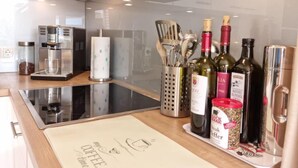 Cocina moderna con cafetera, botellas de vino y una pizarra con escritura.