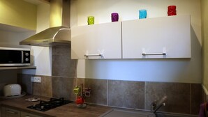 A kitchen with a microwave, stove, and cabinets.