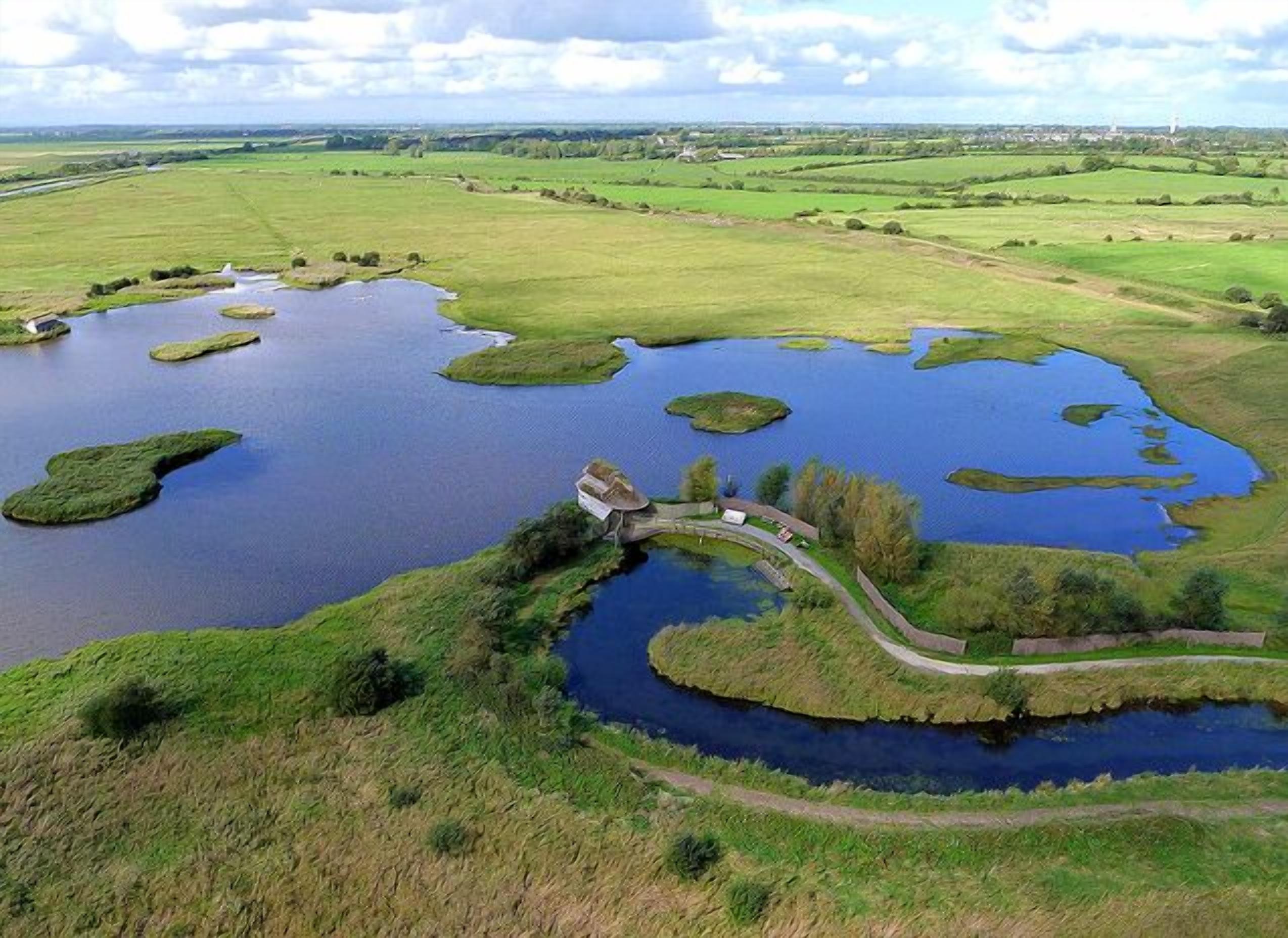 An aerial view of a lake with several small islands and a bridge connecting them.
