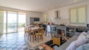 A modern kitchen with a dining area, large windows, and a checkered floor. - Hilly Trullo with Sea View (Leuca)