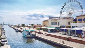 A waterfront area with a Ferris wheel, boats docked along the canal, and outdoor seating at nearby cafes. - Beautiful home in Viareggio with WiFi (Viareggio)