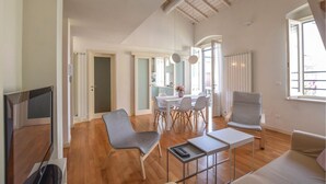 A spacious living area with a dining table, chairs, a sofa, and a TV. - Beautiful home in Viareggio with WiFi (Viareggio)