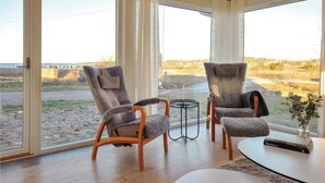 Ein modernes Zimmer mit zwei bequemen Sesseln, die ein großes Fenster mit Blick auf eine reizvolle Landschaft zeigen.