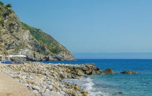 A rocky beach with a clear view of the sea and a hill with vegetation. - Cozy home in Joppolo with WiFi (Joppolo)