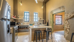 A modern kitchen with a central island, bar stools, and a built-in oven.
