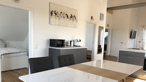 Eine moderne Küche mit Mikrowelle, Kaffeemaschine und Schränken.