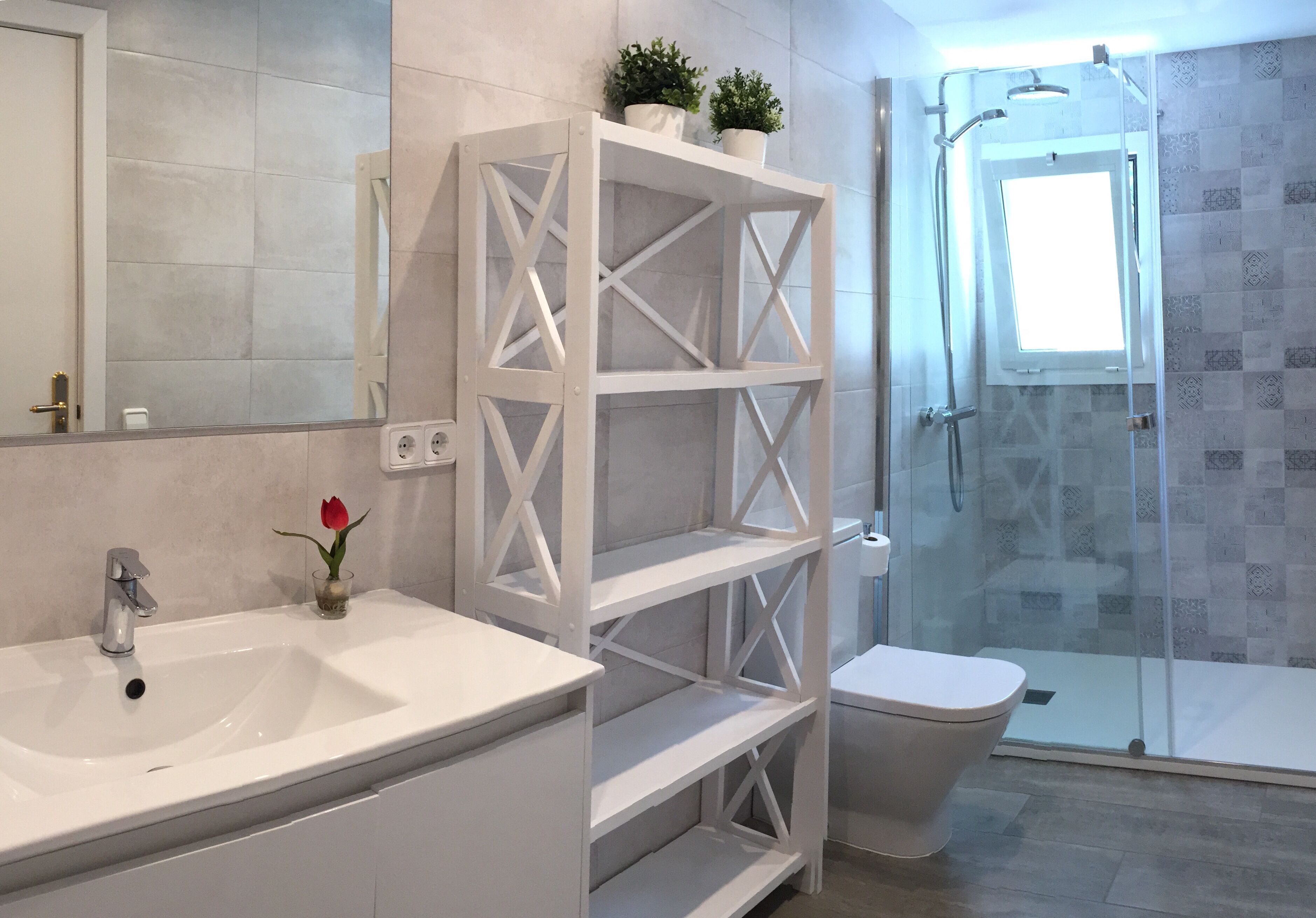 A bathroom with a white sink, a glass shower enclosure, and a toilet.