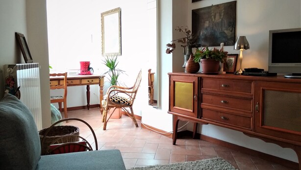 A living room with a wooden cabinet, a television, and a potted plant.