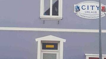 Ein Gebäude mit einem Schild, auf dem 'CITY URLAUB' und 'FERIENWOHNUNGEN' stehen.