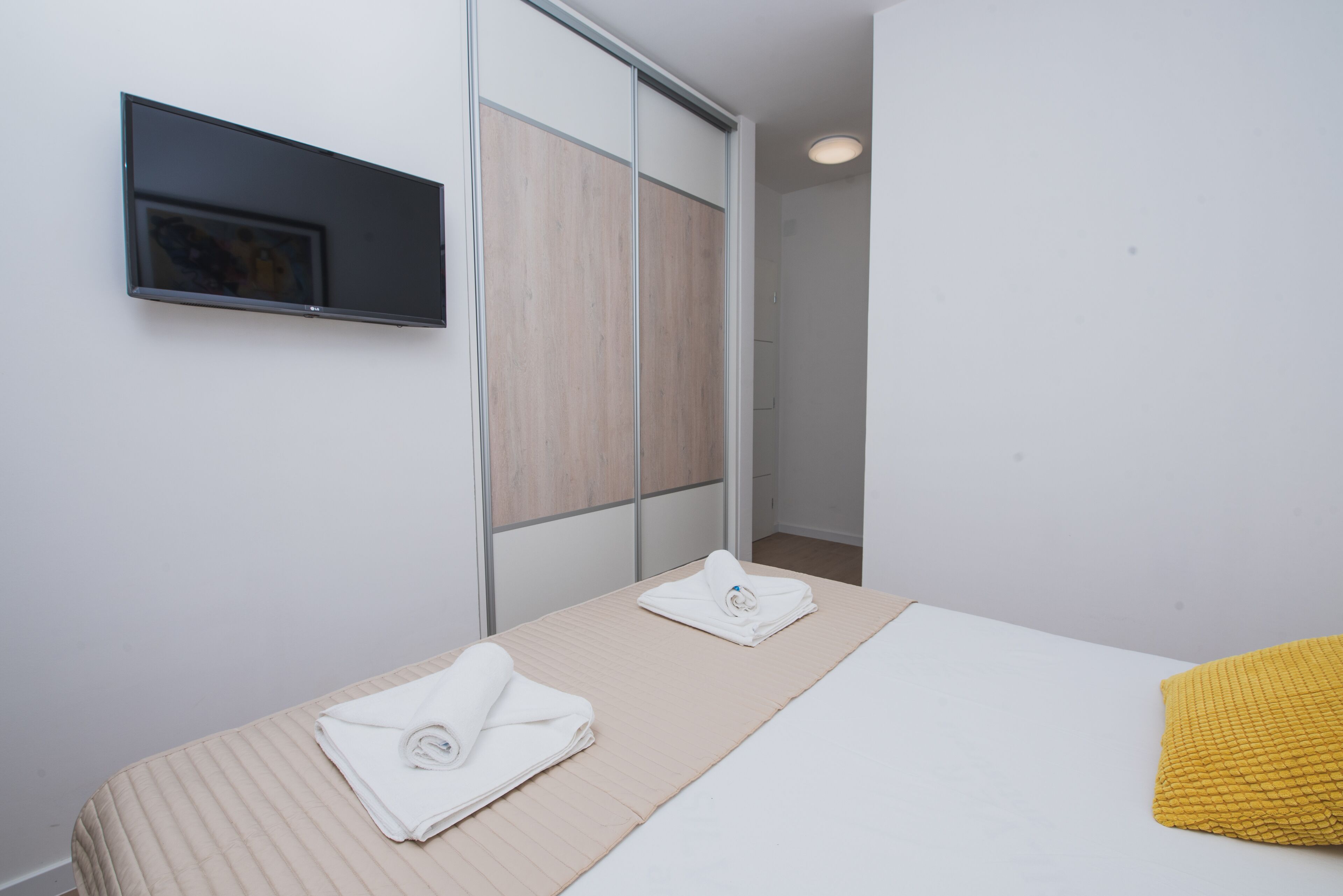 Ein Hotelzimmer mit einem Bett, einem flachbildfernseher an der Wand und einem Schiebetürenschrank.
