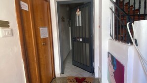 Un escalier avec un paillasson, une porte avec une pancarte et un mur orné du mot « AMOUR ».