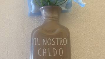 Eine Vase mit blauen Blumen und Schrift auf einer Wand.