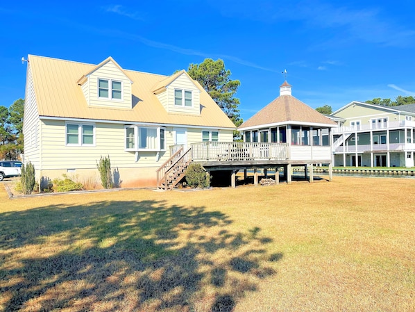 A large two-story house with a covered porch and a small tower-like structure on the roof.